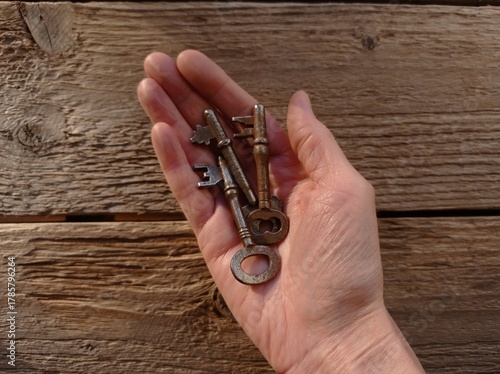 A close-up of a few old keys in a woman's hand.