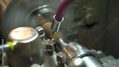 Close-up of a metal part spinning on a lathe machine. The cutting tool removes shavings with precision, showcasing industrial craftsmanship and mechanical beauty