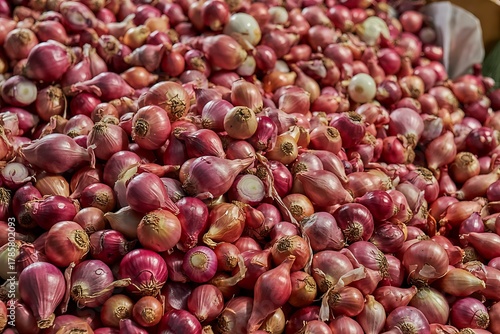 Large pile of fresh shallots displayed at market for sale