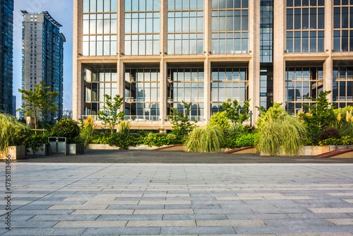 Modern Urban Building with Greenery on Rooftop and Open Plaza