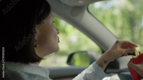 Woman Eating French Fries While Driving. Distracted Driving Scene