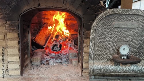 Flames start to rise as the pizza oven is heated for cooking.