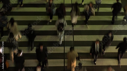 TOKYO, JAPAN : Aerial high angle top view of zebra crossing at night. Crowd of people (commuters) walking down the street. Japanese people and lifestyle concept video.