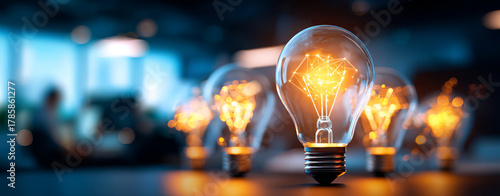 Bright light bulbs glowing with innovative ideas in modern workspace