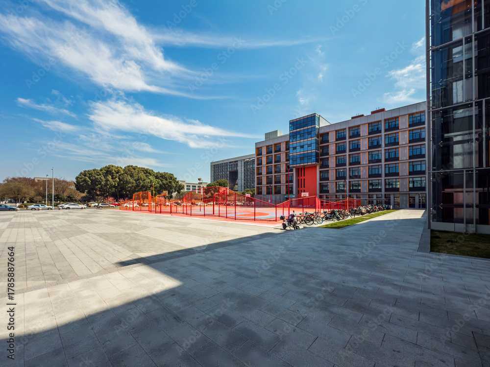 Obraz premium Vibrant Modern Campus Featuring Dynamic Sports Area and Lush Greenery