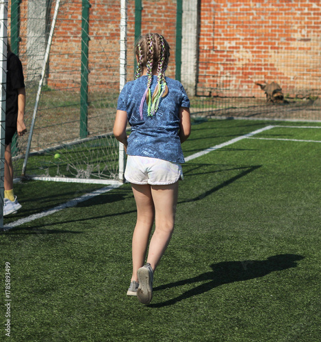 a girl with pigtails is training on a football field