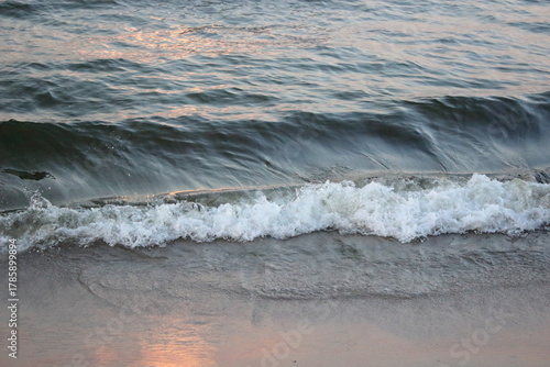 Fototapeta Naklejka Na Ścianę i Meble -  Sea wave washing sandy beach at sunset