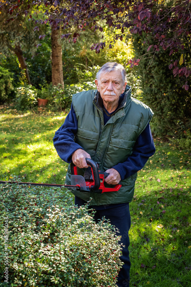 Obraz premium Active senior man doing yardwork