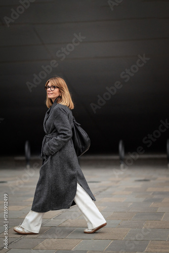 Wallpaper Mural Blond haired happy woman walking in front of a grey wall outdoor Torontodigital.ca