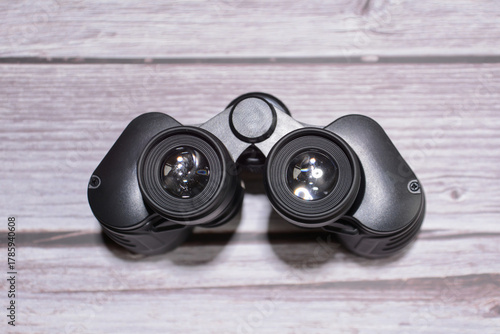 Binoculars on a wooden table. Black binoculars. Set of black binoculars on wooden background