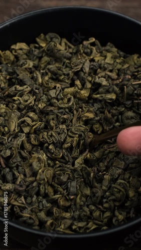 Dried green tea leaves taking with spoon