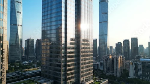 Aerial shot of a modern city with towering glass skyscrapers and surrounding buildings