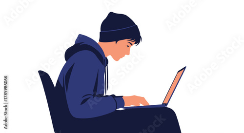 Young person wearing a beanie and hoodie focused on typing on a laptop computer while sitting in a chair