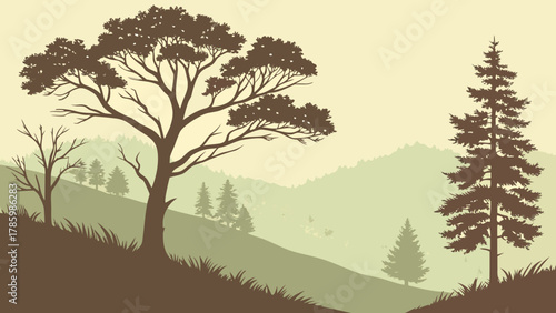Silhouette of trees on a hillside against a misty mountain backdrop