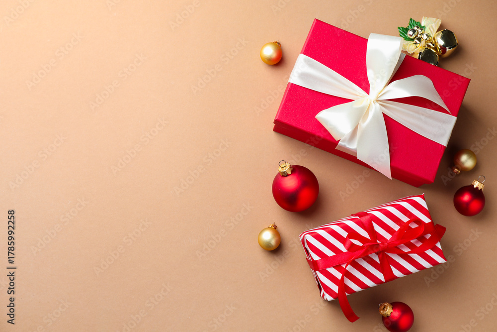 Obraz premium Gift boxes and Christmas decor on beige background, flat lay. Space for text