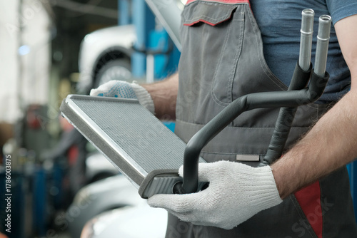 Car maintenance at a car service station.Repair of the air conditioning system.An auto mechanic is preparing the replacement and installation of a new front air conditioner evaporator.