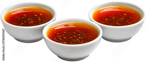 Three elegant white bowls filled with rich, aromatic tea garnished with spices, set against a clean background, suggesting a peaceful tea-drinking experience