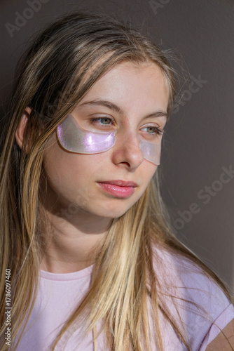 Foto preteen girl using pink sparkling eye patches fun beauty concept