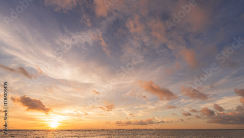 Sunset sky clouds over sea water background in evening with orange, blue sun light, Horizon sea ocean sunrise sky landscape nature backgrounds and gold sun down in golden hour summer season, Dusk sky