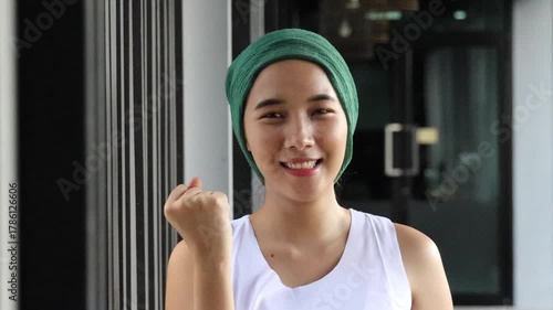 Confident encouraged hopeful healthy and strong asian woman cancer patient with head scarf getting a good cure in rehabilitation facility, real female person model