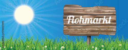 Ein Schild mit dem Wort Flohmarkt auf der Wiese vor blauem Himmel Header