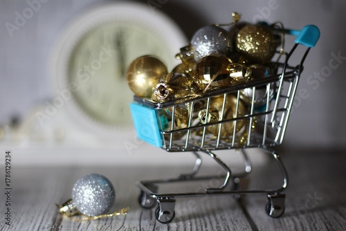 Christmas decor balls in the shopping cart trolley concept photo preparation for holiday new Year festive background shop trade sale 