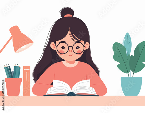 Young woman with glasses reading a book at a desk, studying.