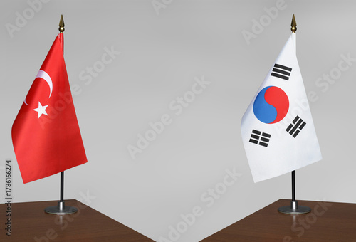 Table flags of Turkey and South Korea on grey blurred background