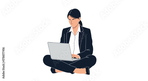 Focused business woman in a suit sitting cross legged on the floor working on a laptop computer