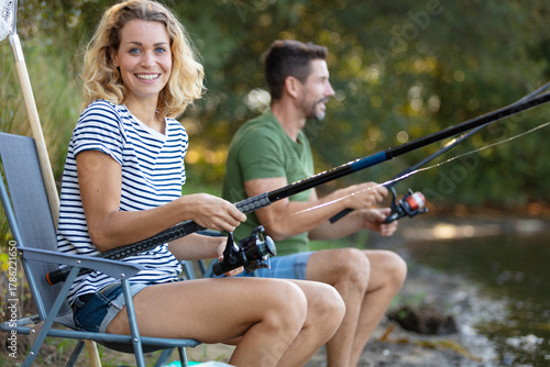 man and woman fishing with angle together at river shore