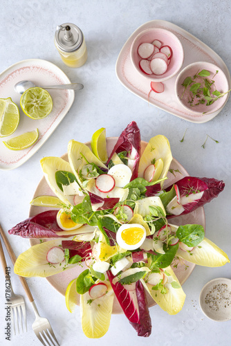 Salat mit Chicoree, Radicchio, Radieschen, gekochten Eiern und Limettendressing
