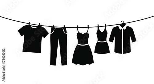 A collection of black clothing items hangs on a clothesline secured by clothespins.