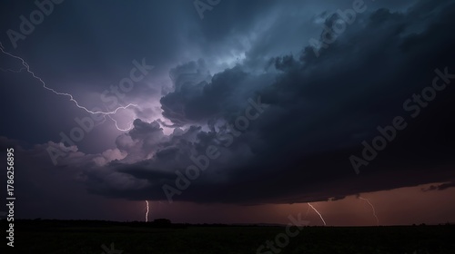 Dramatic lightning strikes illuminate a powerful thunderstorm over a dark, silhouetted landscape creating a breathtaking natural spectacle.