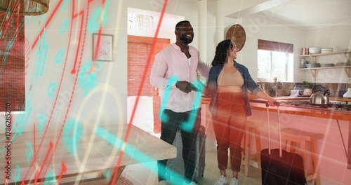 Standing couple smiling, holding roller suitcases near wooden kitchen island, wearing denim jacket