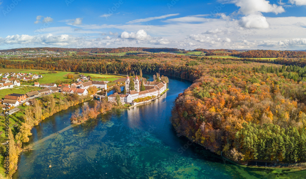Fototapeta premium Aerial panorama view of the Rheinau Abbey Islet on Rhine river in autumnal splendid colors, Switzerland