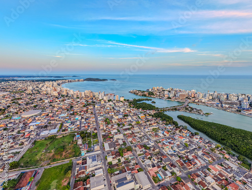 Imagem aérea do canal de Guarapari no por do sol, ao fundo mostrando a praia do morro, o centro da cidade, a ponte e o bairro do Itapebussu.
