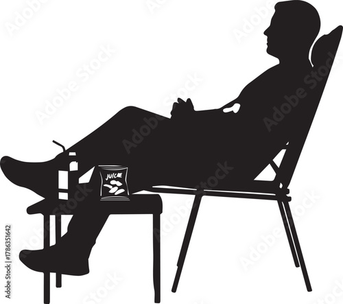 Man relaxing silhouette sitting in chair with legs up and holding something