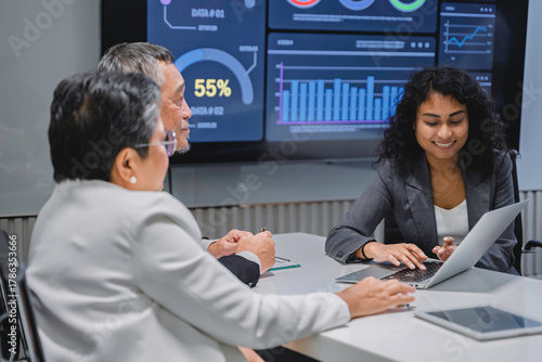 Diverse business team analyzing financial data and performance metrics during a corporate meeting. Professional teamwork, strategy planning, and data-driven decision making in modern office.