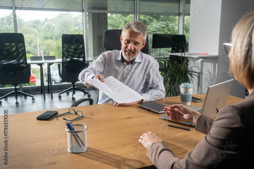 Fotografie Woman consulting male financial advisor in bank office for investment planning, money management, and advice