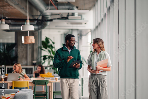Business colleagues discussing work walking in modern office
