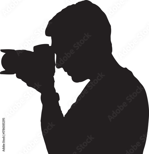 A photographer holds his camera to his eye preparing to take a in silhouette
