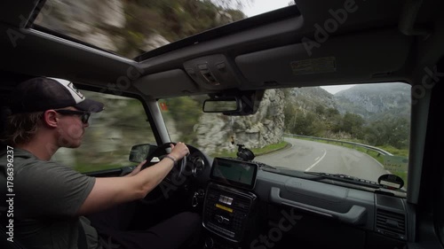 Wallpaper Mural POV from inside a car of young driver navigating a winding road through a rocky mountain landscape. Road trip and adventure concept Torontodigital.ca