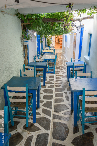 Fototapeta Naklejka Na Ścianę i Meble -  Traditional alleyway dining on cobbled street in Naxos Chora, Cyclades, Greece