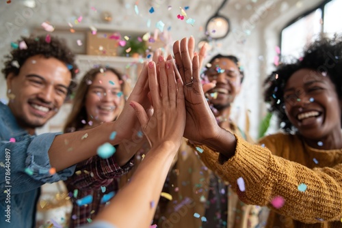 Friends celebrating with high-fives and confetti