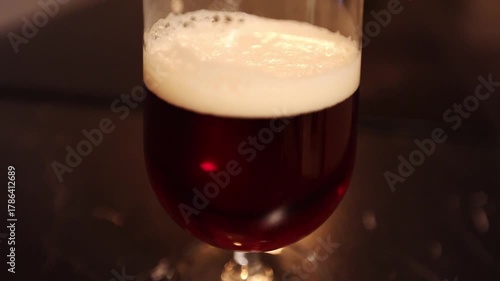 Dark craft lager beer in beer glass, dark environment and light effect.