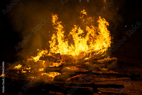 logs on fire for the hindu festival of holi lohri or a cremation pyre showing the celebration of this harvest festival across India
