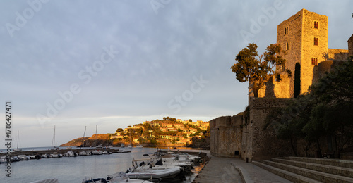 Fototapeta Naklejka Na Ścianę i Meble -  Sunset view of colourful Collioure, narrow streets and yellow, pink, orange houses, summer vacation destination town with historical buidings and beaches, Pyrenees-Orientales, France