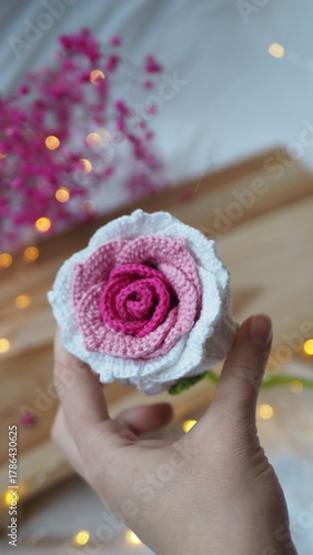 dłoń z sztuczną różą