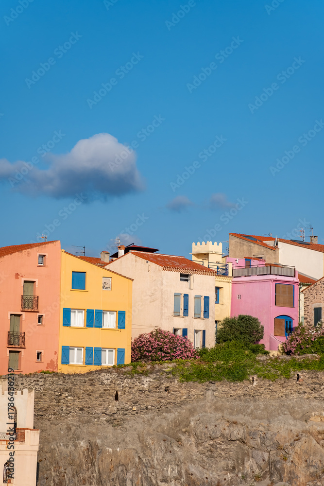 Fototapeta premium View of colourful Collioure, narrow streets and yellow, pink, orange houses, summer vacation destination town with historical buidings and beaches, Pyrenees-Orientales, France