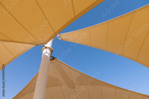 The yellow canopy is photographed against a blue sky background